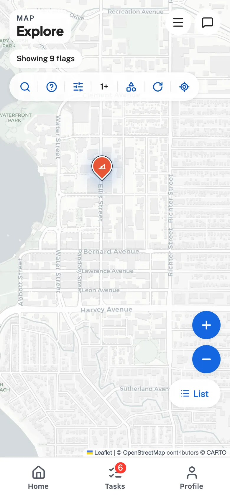 Flagstone's full map — severity-coloured barrier pins over street tiles of downtown Kelowna, a nearest-barrier banner up top and rounded zoom controls at the edge.